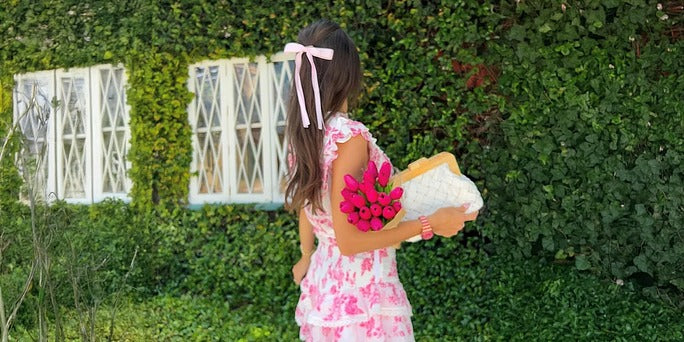 a woman holding flowers and wearing a Valentine’s Day date night outfit